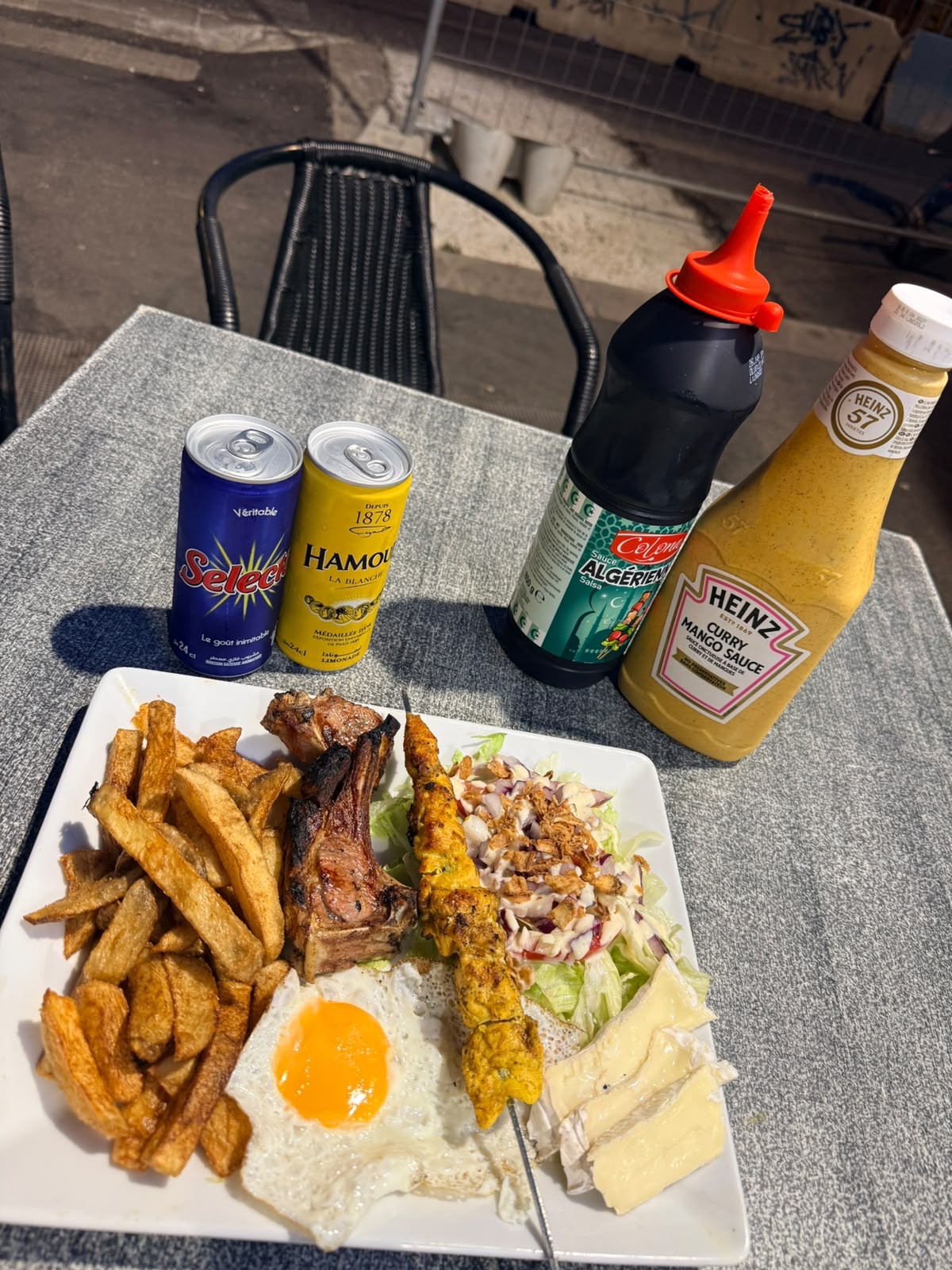 Assiette côtelette d'agneau, brochette de poulet curry, œuf au plat, camembert et frites maison