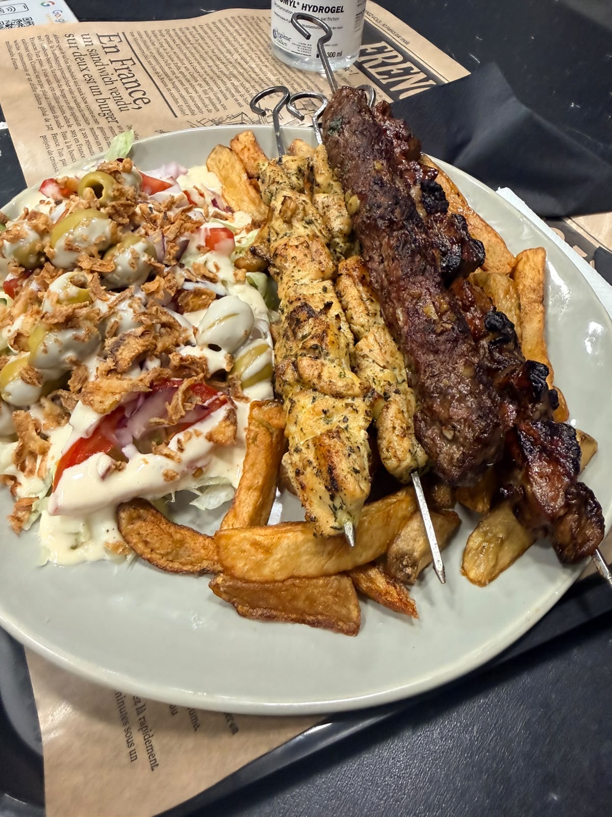 Assiette mixte brochette de poulet mariné et brochette de bœuf grillées au feu de bois, frites maison et salade composée